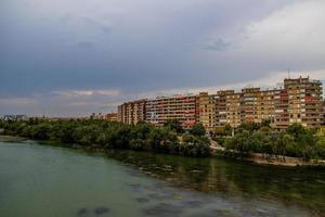 lof the Ebro river and apartment blocks in Zaragoza, Spain on a cloudy summer day photo