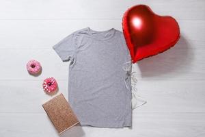 Grey tshirt mockup. Valentines Day concept shirt, balloons heart shape on wooden background. Copy space, template blank front view t-shirt clothes. Romantic outfit. Flat lay birthday holiday fashion photo