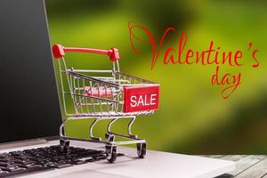 Shopping basket and gifts for Valentine's or Christmas with color bokeh on background photo