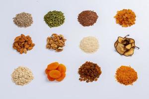 Healthy vegetarian food concept. Assortment of dried fruits, nuts and seeds on white background. Top view. photo