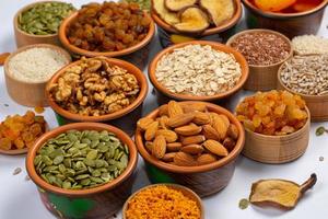 Healthy vegetarian food concept. Assortment of dried fruits, nuts and seeds on white background. Top view. photo