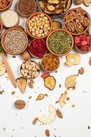 Healthy vegetarian food concept. Assortment of dried fruits, nuts and seeds on white background. Top view. photo