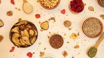 Healthy vegetarian food concept. Assortment of dried fruits, nuts and seeds on white background. Top view. video