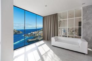 White couch against huge window with panoramic view photo
