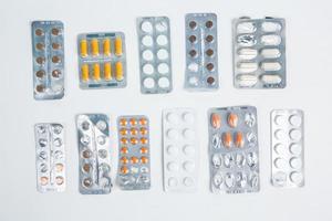 Pills in blister pack on white background. Tablets and capsules in blister packs. Top view, copy space. photo