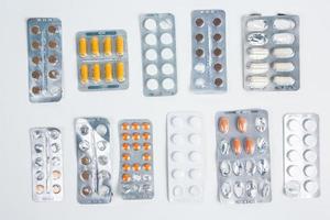 Pills in blister pack on white background. Tablets and capsules in blister packs. Top view, copy space. photo