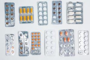 Pills in blister pack on white background. Tablets and capsules in blister packs. Top view, copy space. photo