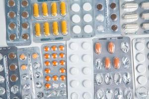 Pills in blister pack on white background. Tablets and capsules in blister packs. Top view, copy space. photo