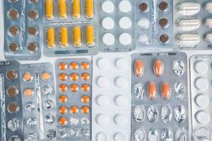 Pills in blister pack on white background. Tablets and capsules in blister packs. Top view, copy space. photo