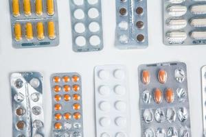 Pills in blister pack on white background. Tablets and capsules in blister packs. Top view, copy space. photo