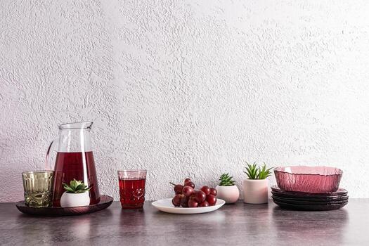 kitchen background with modern utensils, jug with grape juice, a branch of grapes on a plate. still life. front view. a copy space. photo