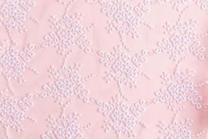 Lace background with colors. abstract lace. floral ornament. white embroidery on delicate pink satin. photo