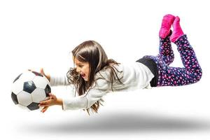 morena pequeño niña con un fútbol pelota aislado en un terminado blanco antecedentes foto
