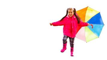 pretty child in rubber boots, yellow raincoat with umbrella, isolated on white photo
