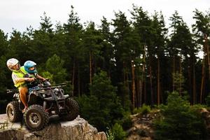 Happy family riding and looking quad bike on mountain. Cute boy on quadricycle. Family summer vacation activity. photo