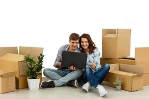 couple sitting with laptop. Hugging and smiling isolated on white background photo