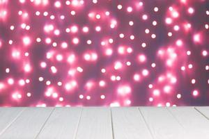 Abstract background, mockup. Defocused pink lights bokeh and white wooden surface photo