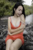 retrato de sexy asiático mujer a el cascada, sentimiento Fresco a el río, tailandés hembra relajarse a país foto
