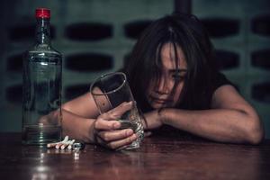 Asian woman drink vodka alone at home on night time,Thailand people,Stress woman drunk concept photo