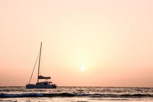 Sailing yacht at sunset photo