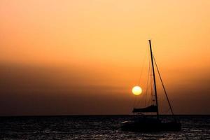 Sailing yacht at sunset photo