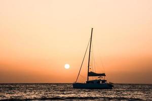 Sailing yacht at sunset photo