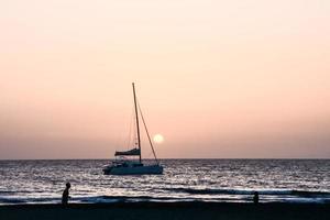 Sailing yacht at sunset photo