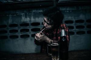 Asian man drink vodka alone at home on night time,Thailand people,Stress man drunk concept photo