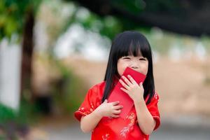 retrato hermosa asiático pequeño niña en cheongsam vestido,tailandia gente feliz chino nuevo año concepto,feliz pequeño asiático niña en chino tradicional vestir foto