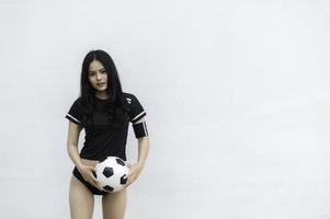 joven y hermosa mujer asiática viste a un jugador de fútbol animando el deporte, las hinchas femeninas animan el juego de fútbol foto