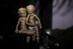 Dolls couple sitting in handlebar of bycicle. romantic photography concept. photo