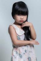 retrato asiático linda pequeño niña actitud para tomar un foto en estudio en blanco antecedentes