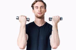 atleta con pesas en su manos y en un negro camiseta ejercicio aptitud carrocero foto