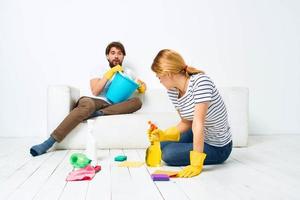 Young couple are doing cleaning together in the room light background photo