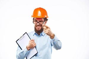 A man in orange paint in glasses documents a manual industry photo