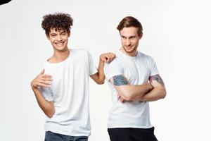 dos alegre amigos en blanco camisetas abrazo emociones foto