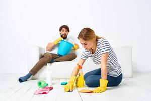 Young couple are doing cleaning together in the room light background photo