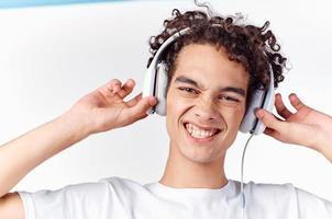 man with curly hair and in headphones listens to music photo