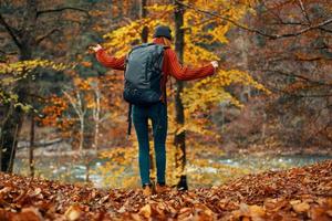 mujer en un suéter y pantalones y botas en otoño en un parque en naturaleza cerca el río foto