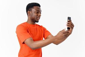 man of African appearance in an orange T-shirt on a light background cropped view Model Copy Space photo