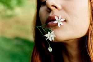 Woman holding a spring flower in her hand in sunlight, conservation and ecology photo