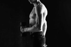 hombre con pesas en manos bombeo arriba músculos ejercicios foto