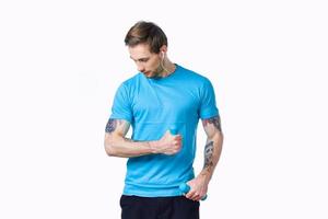 guy with dumbbells go in for sports in a blue t-shirt on a light background photo