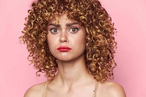 Lady curly hair Sad look red lips close-up pink background photo