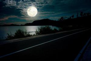 noche paisaje a playa con vacío la carretera y lleno Luna foto