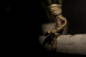 rope doll sitting on steel table. sadness photo