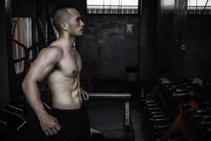 retrato de asiático hombre grande músculo a el gimnasio,tailandia gente,entrenamiento para bueno cuerpo saludable peso entrenamiento, fitness a el gimnasio concepto, broma a abdominal músculos foto