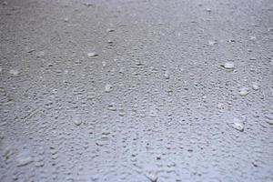 Close-up view on water drops on window in rain. Drops of rain on the glass concept photo. Front view photography with blurred background. photo