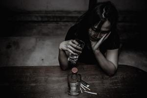 Asian woman drink vodka alone at home on night time,Thailand people,Stress woman drunk concept photo