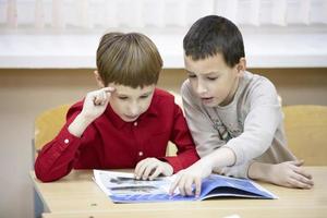 Belarus, the city of Gomil, December 14, 2019. Library. Children in the library. Boys primary school students are reading a book. photo